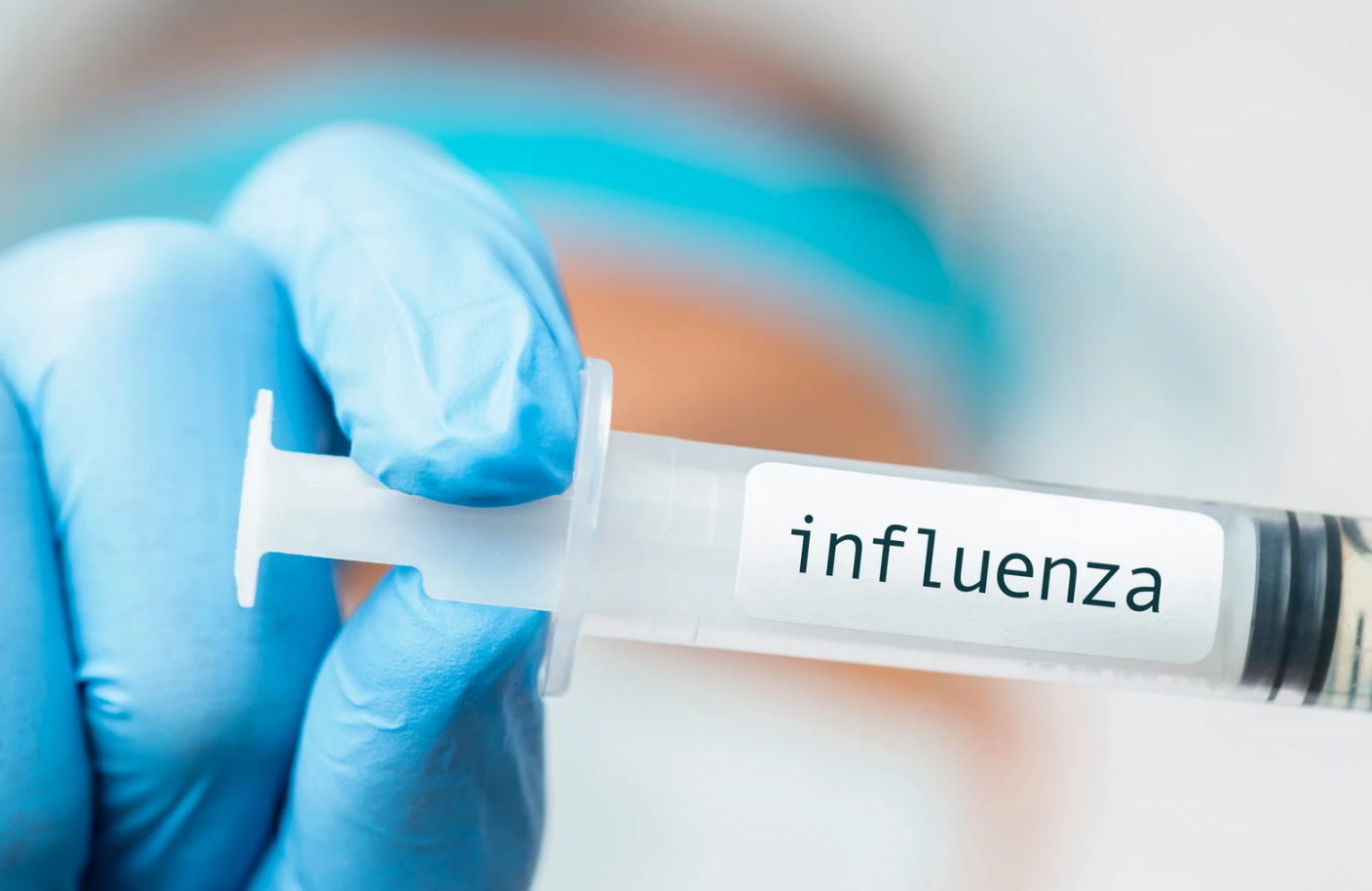 Medizinisches Personal hält eine Spritze mit einem Impfstoff gegen Influenza in der Hand